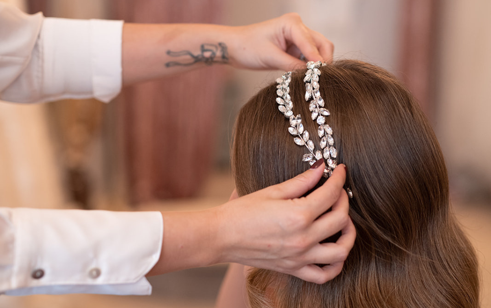 Founder Jessica Jordan fitting Devoted hair piece into a bridal down hairstyle.