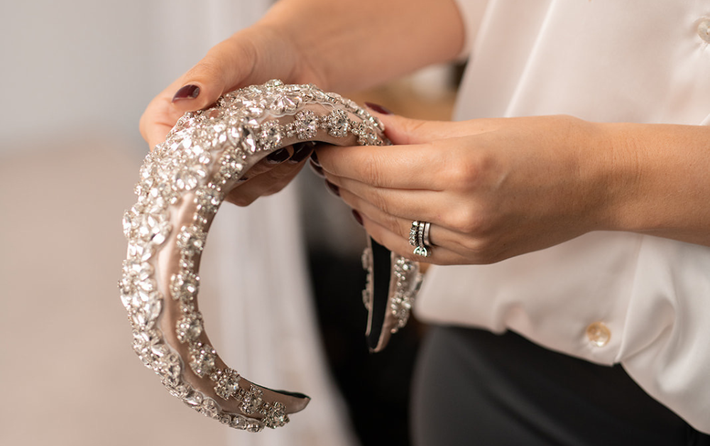 Founder Jessica Jordan holding Devoted bridal hairband in her hands.